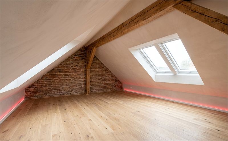 Symbolbild: ausgebautes Dachgeschoss mit Holzbalken, Ziegelgiebel und Dachfenster